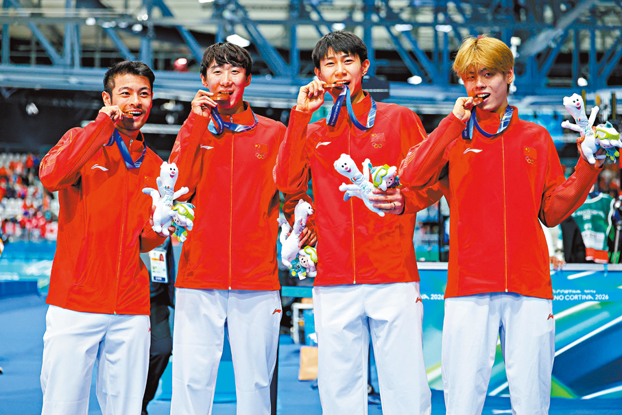 ●中國男子團體追逐賽四名成員（右起）劉瀚彬、李文淏、吳宇與寧忠岩咬着獎牌慶祝。 中新社
