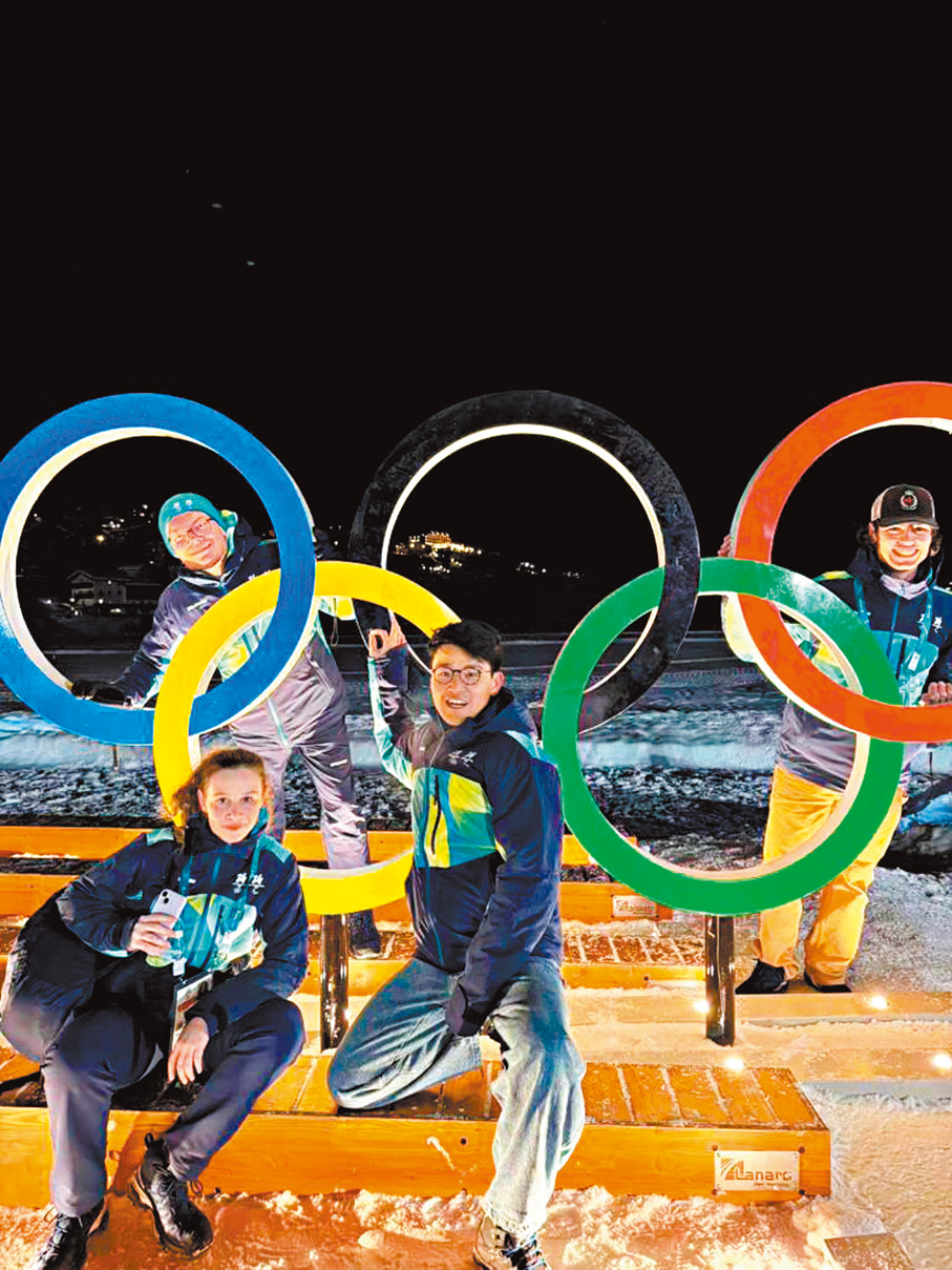 ●中國志願者在五環標誌前合影。新華社