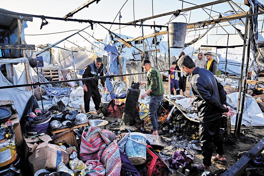 ●巴人在加沙南部汗尤尼斯檢查空襲中受損帳篷。  美聯社
