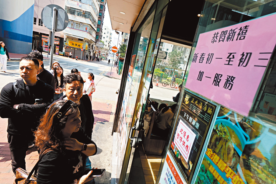 ●有食肆維持初一至初三收取加一服務費，但仍吸引不少人排隊光顧。香港文匯報記者涂穴  攝