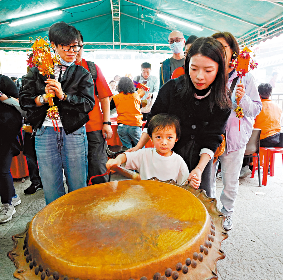 ●一家大細到沙田車公廟祈福，並於廟前擊鼓。  香港文匯報記者曾興偉  攝