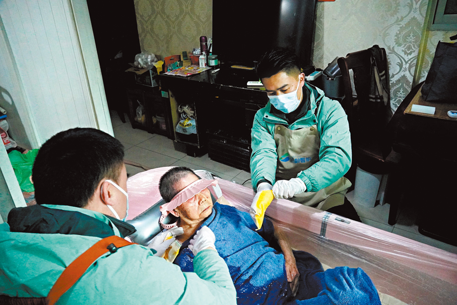 ●「90後」助浴師張龍與搭檔在重慶一戶失能老人家中，正進行專業的上門服務。