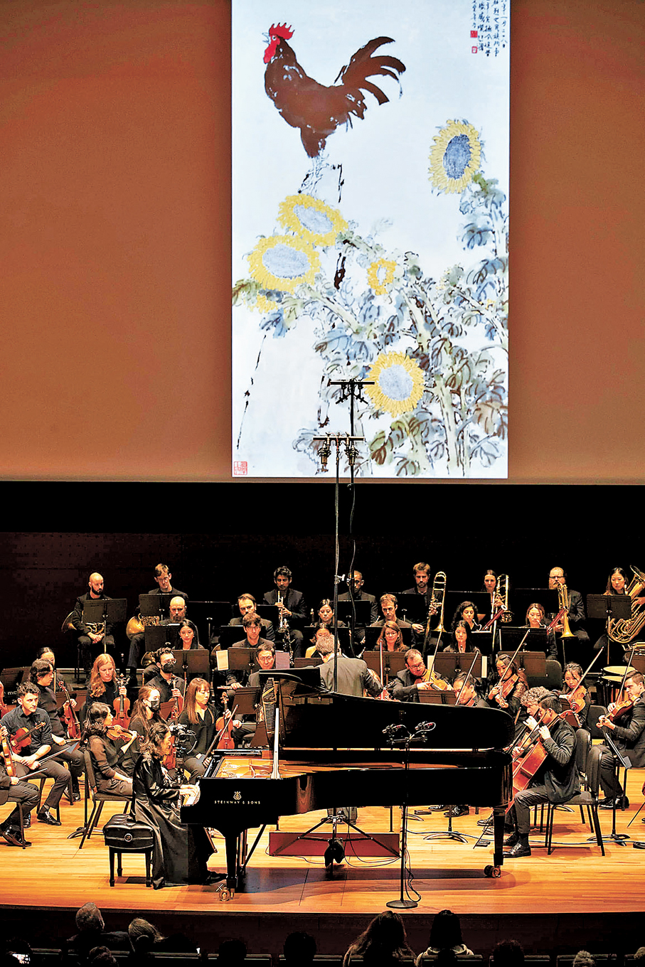 ●2022年，徐芳芳在紐約林肯中心演奏鋼琴協奏曲《徐悲鴻的彩墨畫》第三樂章，舞台上方屏幕同時展示徐悲鴻的畫作。 資料圖片