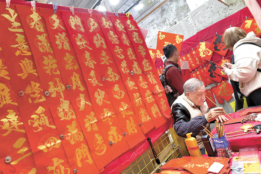 書法老師為市民即席揮毫，寫下一張又一張揮春，讓途人滿載而歸。 香港文匯報記者萬霜靈  攝