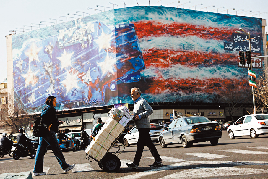 ●伊朗人民走過德黑蘭一塊大型反美宣傳板。 路透社