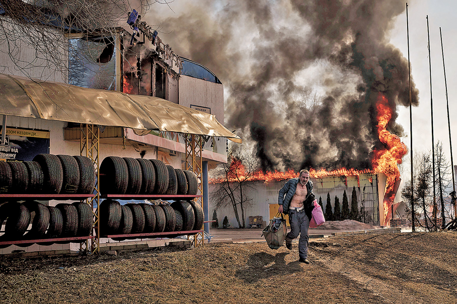 ●2022年3月25日，一名烏男子從一間被俄羅斯擊中的商店逃出。  美聯社
