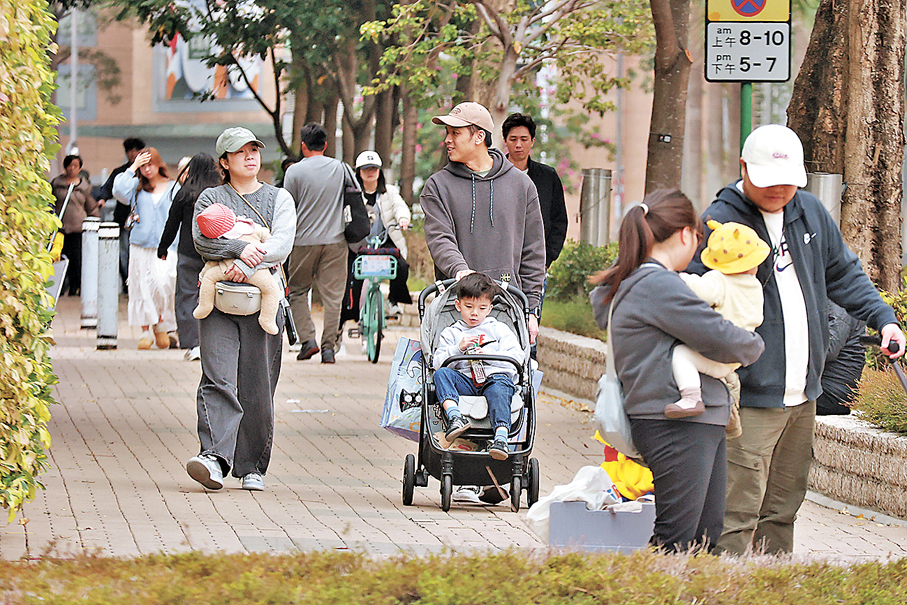 ●財政預算案建議一次過上調個人、單親、已婚，以及供養父母和子女的免稅額，料約209萬名納稅人受惠。圖為一家大細外出逛街樂也融融。  香港文匯報記者北山彥  攝