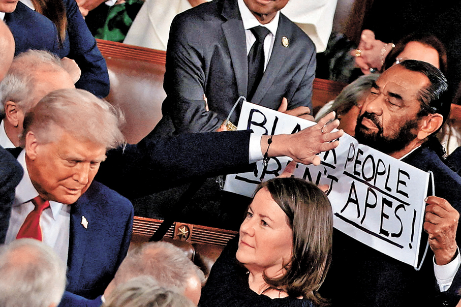 ●格林（右）向特朗普展示標語，其後被逐。 路透社