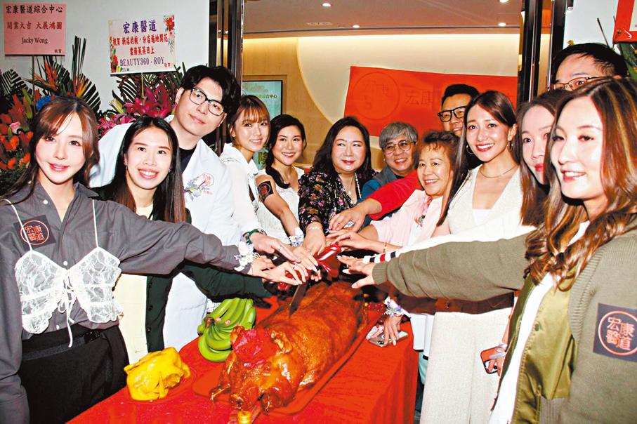 ●眾人齊切燒豬。  香港文匯報記者達里  攝