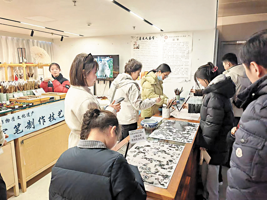 ●遊客在佘徵軍工作室挑選宣筆和練習毛筆字。 中新社