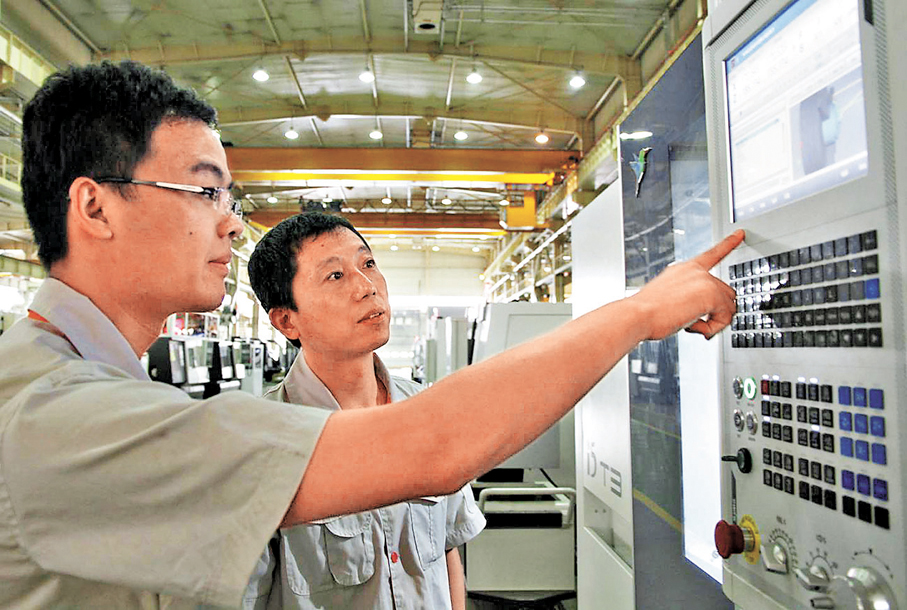 ●徐寶軍（右）和廠裏的年輕人早年在瀋陽機床自主研發的數控機床前作業。 資料圖片