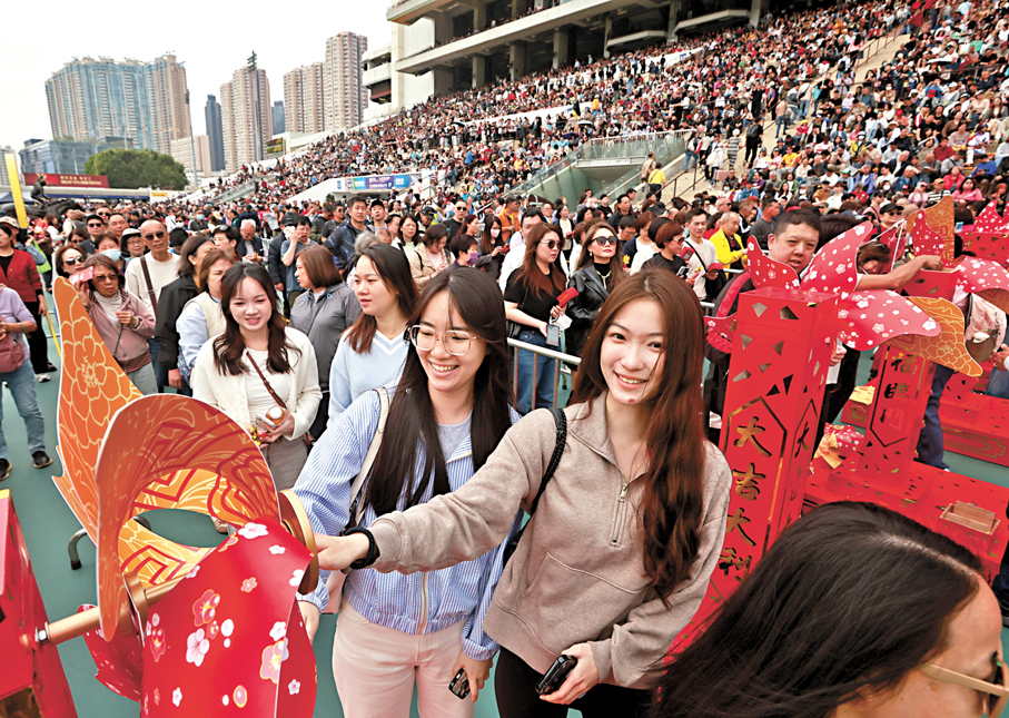 沙田馬場年初三新春賽馬，吸引不少市民和遊客入場，期待發個新年財。同場設有巨型風車陣及桃花陣，讓馬迷打卡留念。 香港文匯報記者郭木又  攝