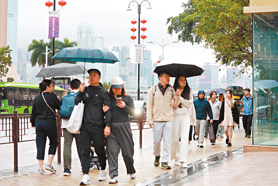 ●昨日天雨路滑，行人紛紛打傘。香港文匯報記者北山彥  攝