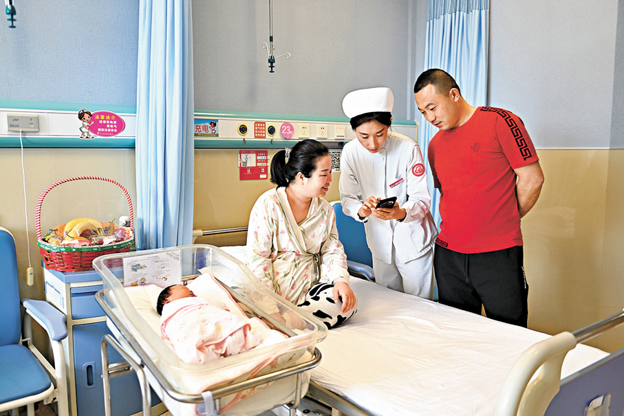 ●內地實施育兒補貼制度，減輕家庭養育負擔。圖為早前內蒙古呼和浩特市婦幼保健院內，護士幫助新生兒家庭申請補貼。 資料圖片