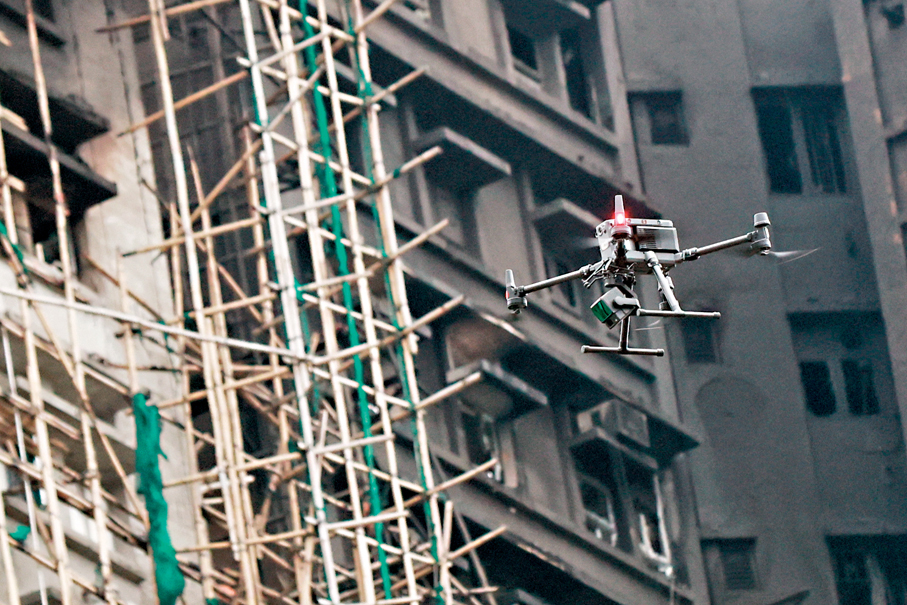 ●政府使用無人機進行各項支援日趨普及。圖為警方去年使用無人機對宏福苑大火現場進行搜索。 資料圖片