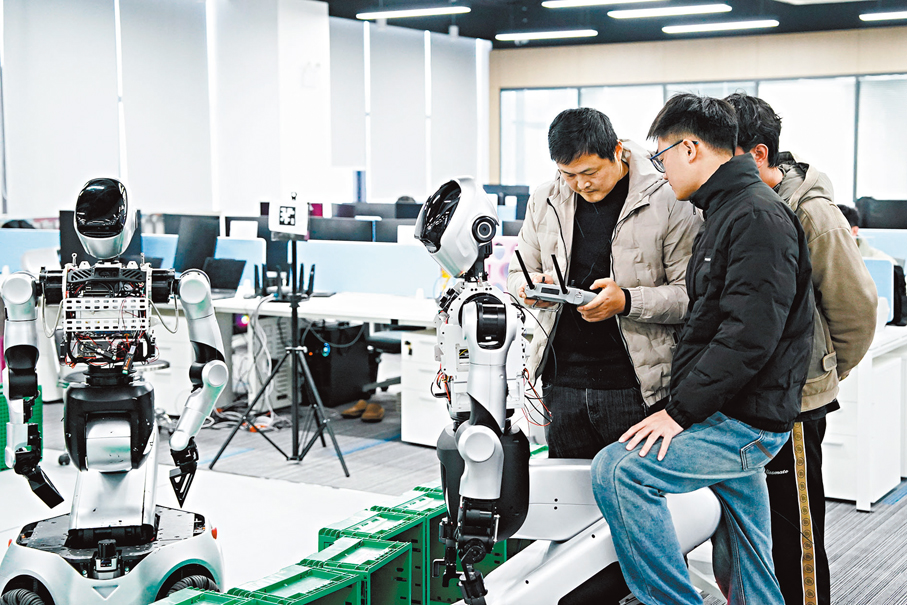 ●「十五五」規劃建議包含三大產業的發展藍圖。圖為早前在合肥樂聚機器人技術有限公司，研發人員調試工業智能機器人。 新華社