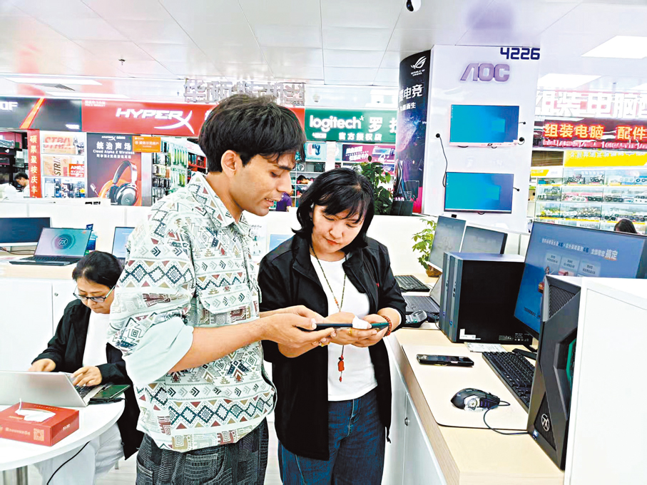 ●阿富汗顧客前來華強北聯想專賣店諮詢購買電腦 。 香港文匯報記者李昌鴻  攝