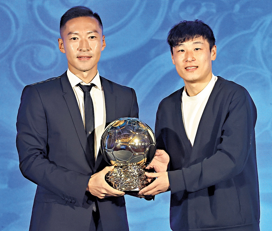 ●國足前鋒武磊（右）向中國金球獎得主吳曦頒獎。   中新社