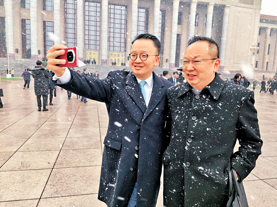 ●港區全國人大代表陳仲尼（右）與港區全國人大代表陳曉峰在大雪中微笑留影。香港文匯報記者郭若溪  攝