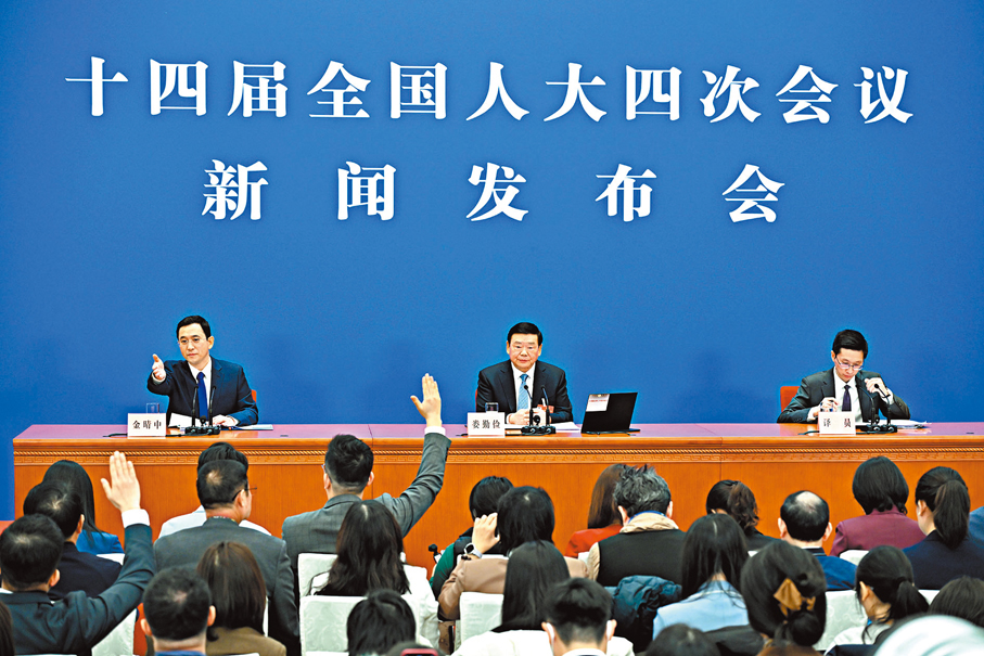 ●3月4日，十四屆全國人大四次會議在北京人民大會堂舉行新聞發布會。大會發言人婁勤儉就大會議程和人大工作相關問題回答中外記者提問。大圖為記者在發布會上舉手提問。小圖為婁勤儉在發布會後繼續和記者交流。 新華社