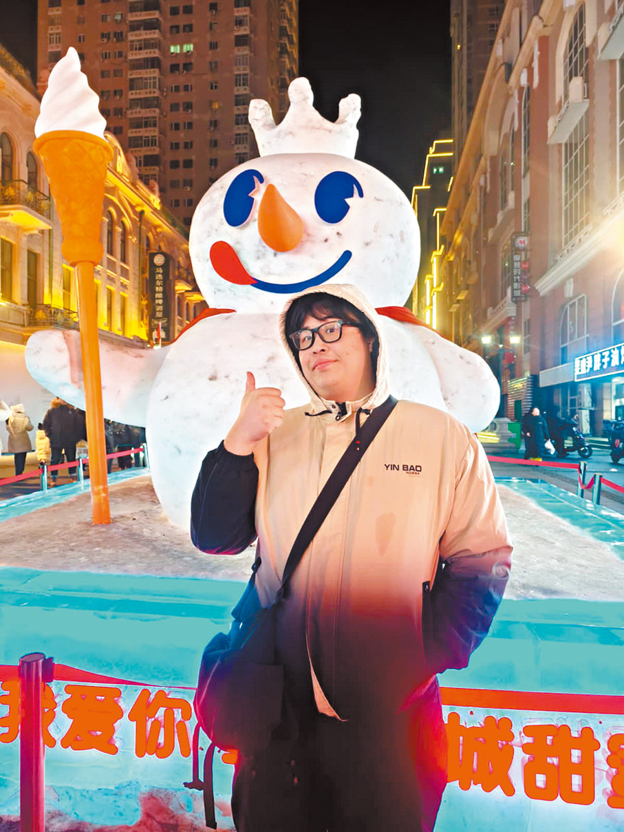 香港遊客趙先生在中央大街冰雕前拍照留念。