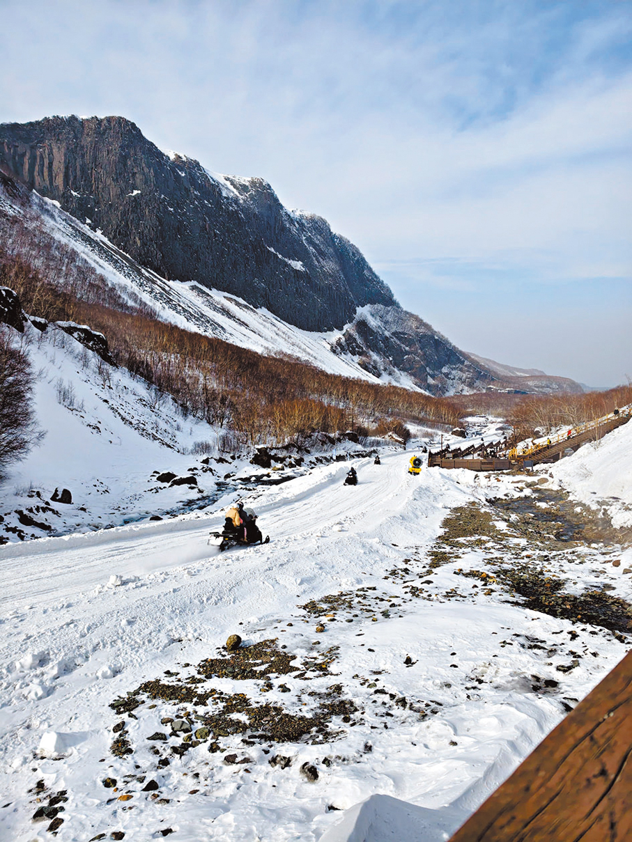 遊客乘坐雪地摩托車往返長白山景區景點。