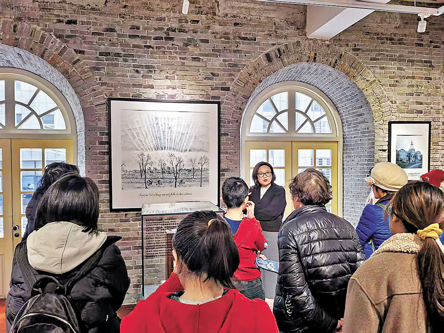 講解員正向遊客講解館內藏品背後的故事。 