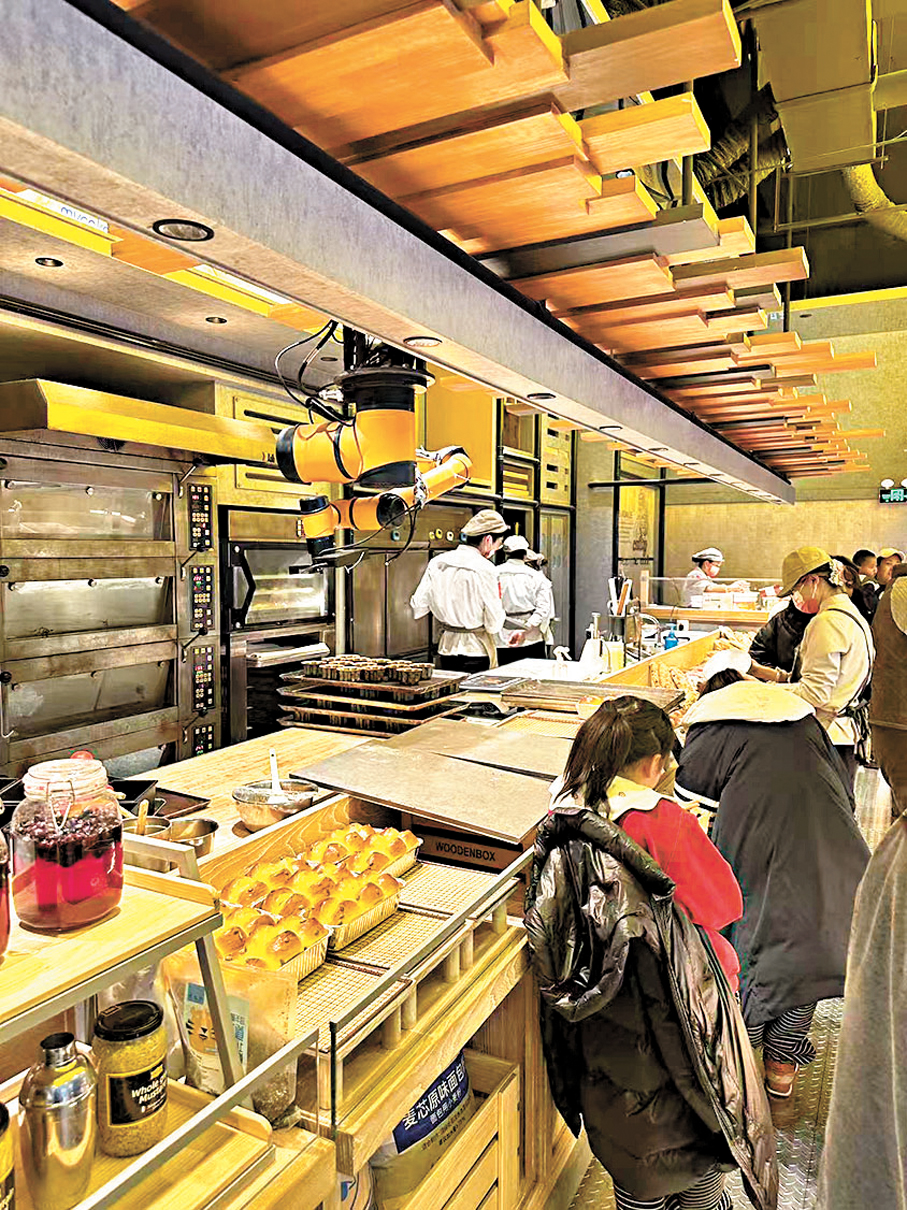 ●港企研發生產的機械臂在麵包店裏「努力」工作。香港文匯報兩會傳真