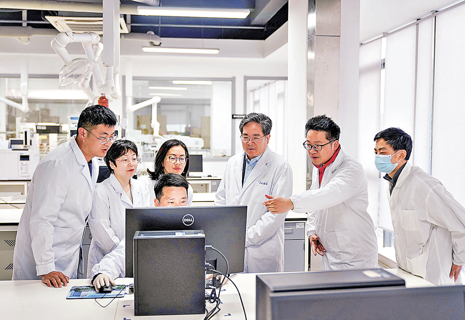 ●全國政協委員、貝達藥業股份有限公司董事長丁列明表示，醫藥創新不僅是科技命題，也是民生命題。圖為丁列明（右三）與研發團隊正在優化一款新藥的藥效驗證方案。 香港文匯報兩會傳真