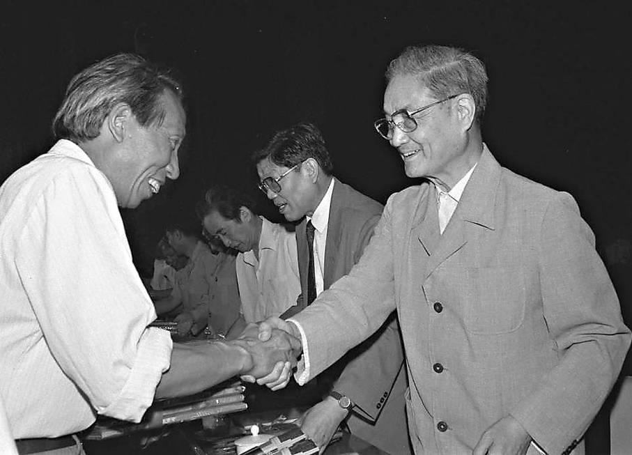 ●1991年6月26日，中共中央組織部、中共中央宣傳部等單位在北京召開大會，表彰全國高校優秀思想政治工作者。這是宋平同志（右）向獲獎的個人頒獎。 新華社