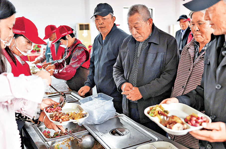 ●代表委員紛紛呼籲盡快提高農民養老金水平。圖為江蘇一條村的長者在村中服務點領取午餐。 資料圖片