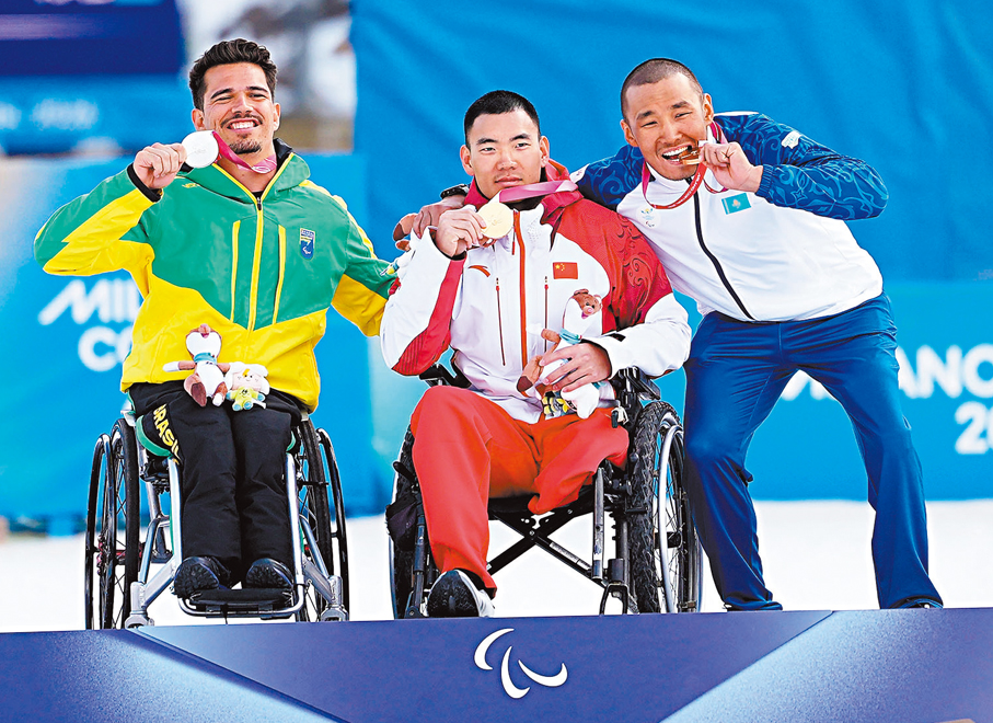 ●劉子旭（中）展示其越野滑雪男子短距離（坐姿）金牌。   新華社