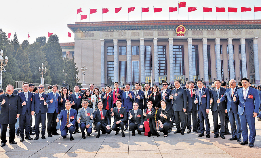 ●3月12日，十四屆全國人大四次會議在北京人民大會堂舉行閉幕會。圖為會前，港區全國人大代表在人民大會堂前合影。 中通社