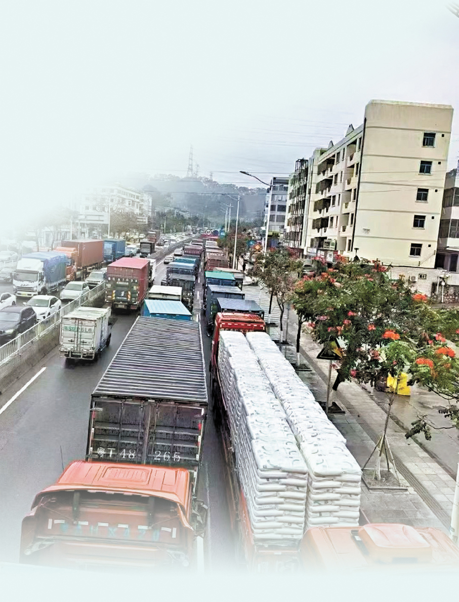 ●進入位於東莞樟木頭塑膠交易市場的莞樟路，從全國各地趕來裝貨卸貨的大貨櫃車密密麻麻地塞滿道路。 香港文匯報東莞傳真