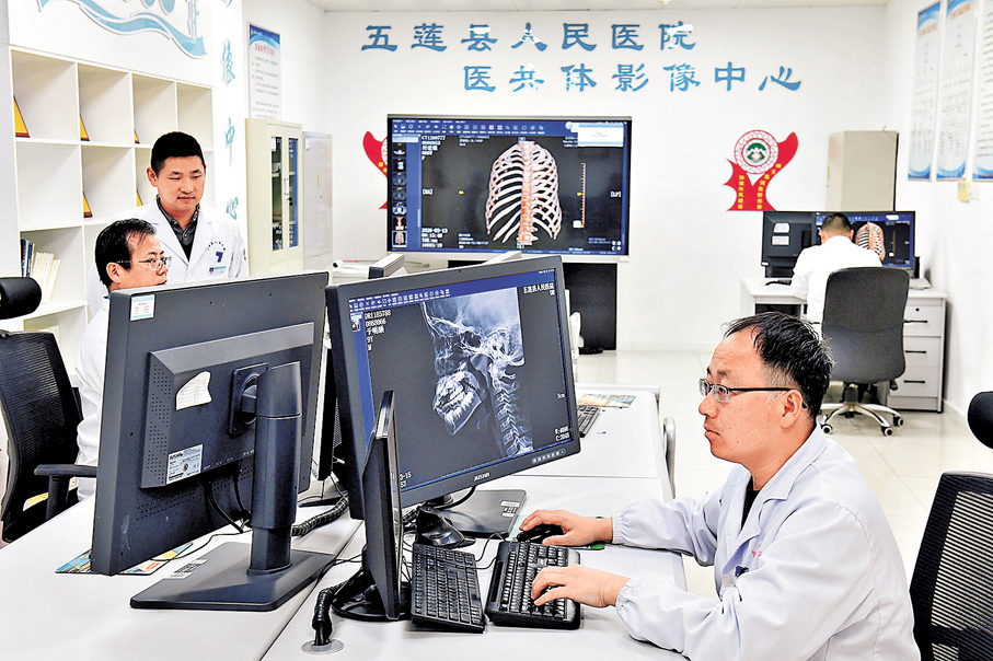 ●3月15日，在日照市五蓮縣人民醫院醫共體影像中心，醫師通過鄉鎮衞生院傳來的影像進行診斷。 新華社