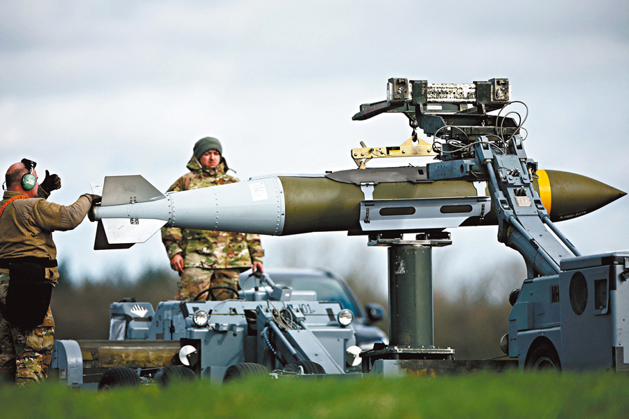 ●美軍在英格蘭費爾福德空軍基地處理B-1轟炸機上一枚導彈。 法新社