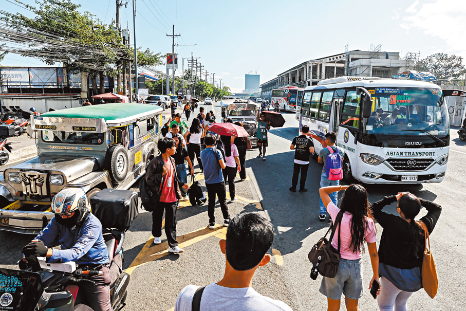 ●菲律賓正在等候吉普尼和公共汽車上班的市民。油價上漲引發運輸團體強烈不滿。  新華社