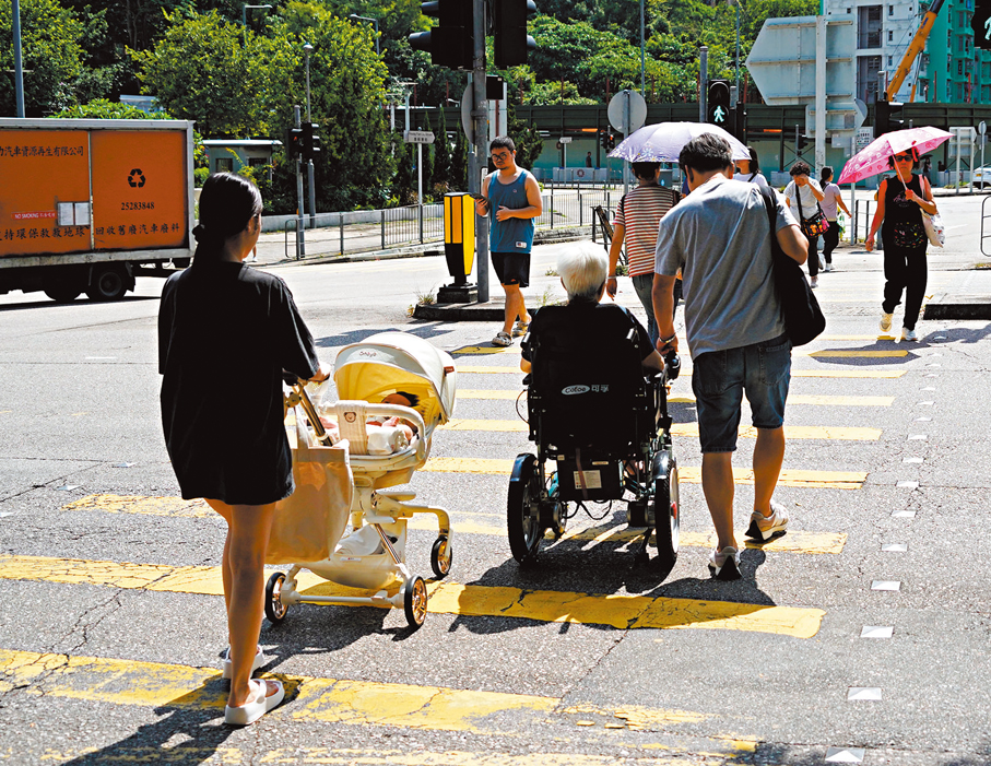 ●多名香港社福界人士指出，制定香港五年規劃時應從中長期治理模式角度出發，以人口數據和社會變化為基礎訂立方向、優次和指標。圖為乘坐輪椅的長者橫過馬路。  資料圖片