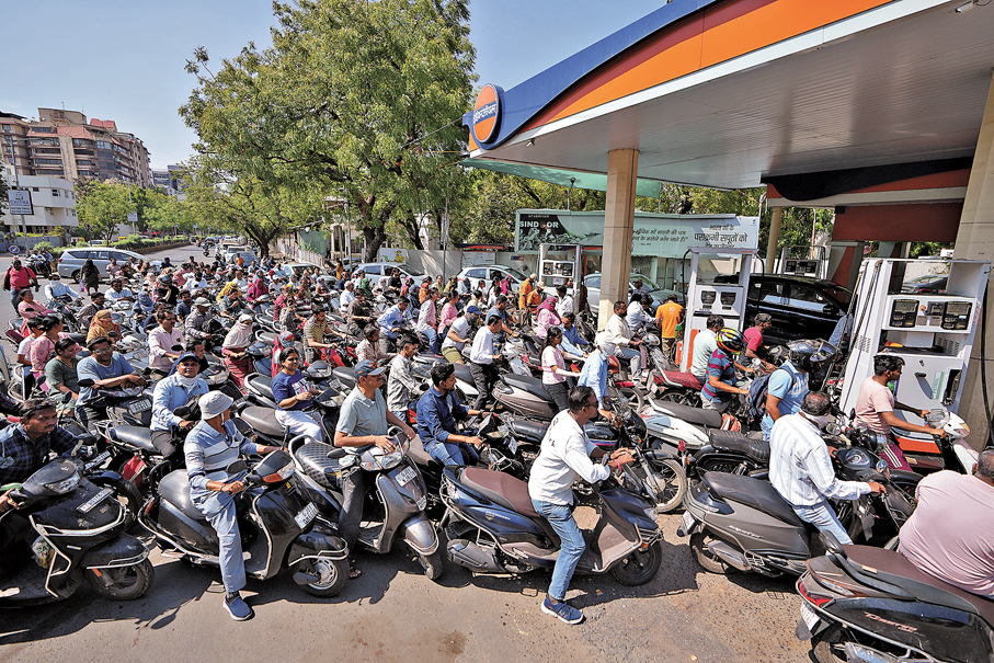 ●伊朗表明若電力設施受襲，將向鄰國能源設施進行報復，加劇全球能源危機，成功令特朗普「褪軚」。圖為印度駕駛人士在油站大排長龍。 美聯社