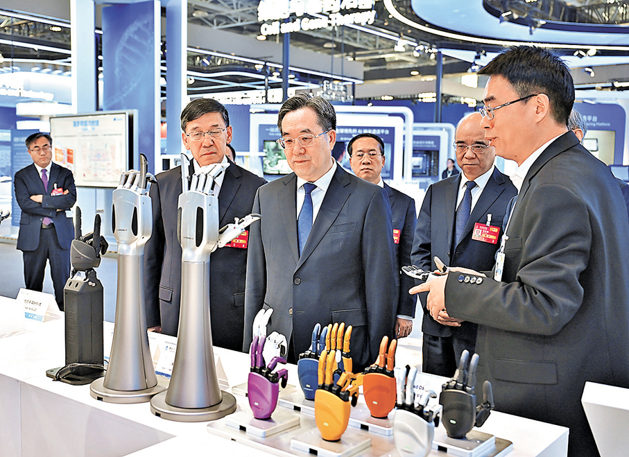 ●3月25日，2026中關村論壇年會在北京開幕。中共中央政治局常委、國務院副總理丁薛祥出席開幕式並致辭。這是開幕式後，丁薛祥巡視中關村展示中心常設展，與科技人員進行交流。 新華社