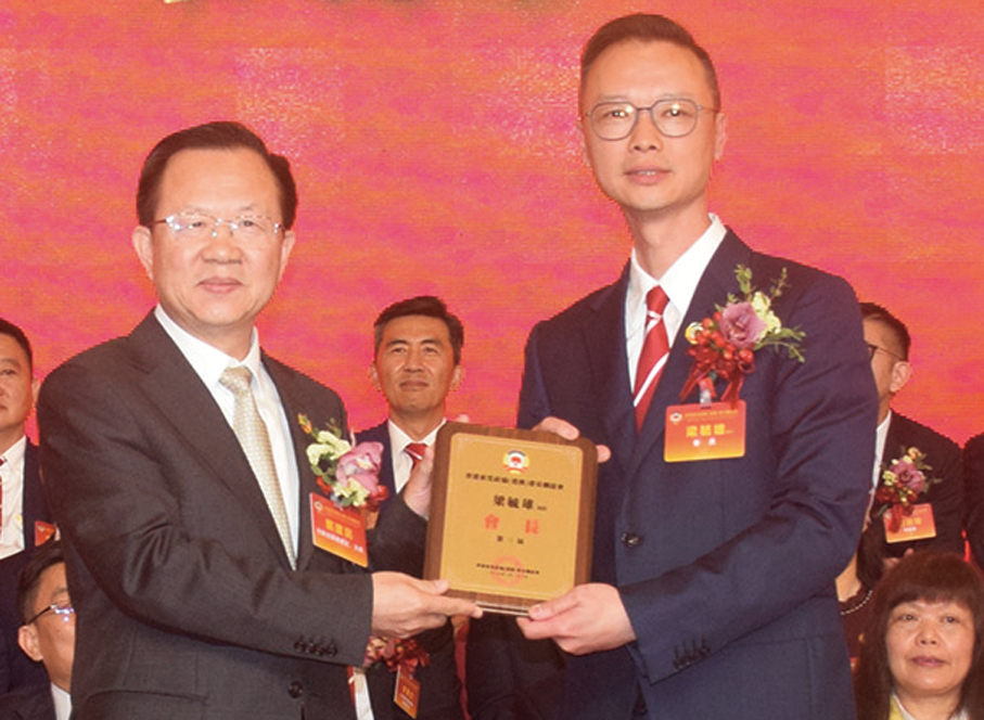 ●鄭建民（左）頒發委任狀予會長梁毓雄。