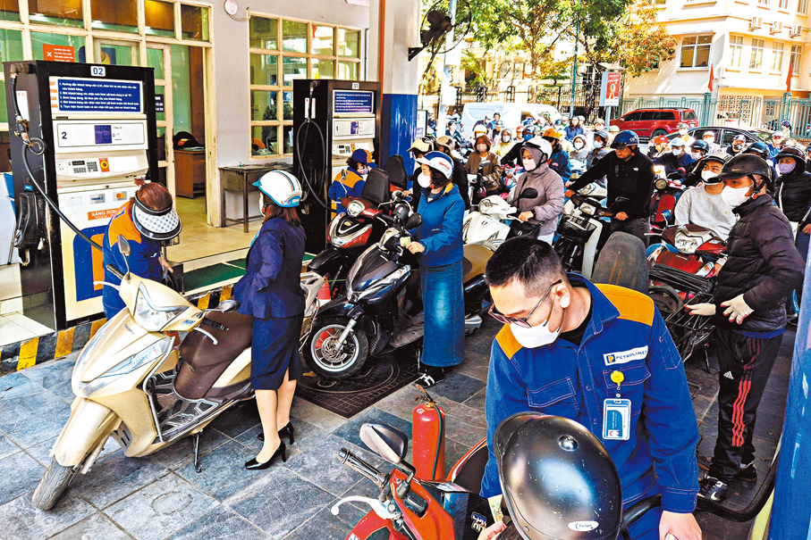 ●河內大批電單車司機在油站外排長龍。 路透社