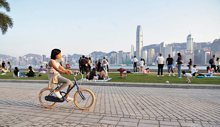 ●迎着海風，女孩在維港天際線的背景下騎行，堅定地駛向屬於她的遼闊未來。 香港文匯報記者曾興偉  攝