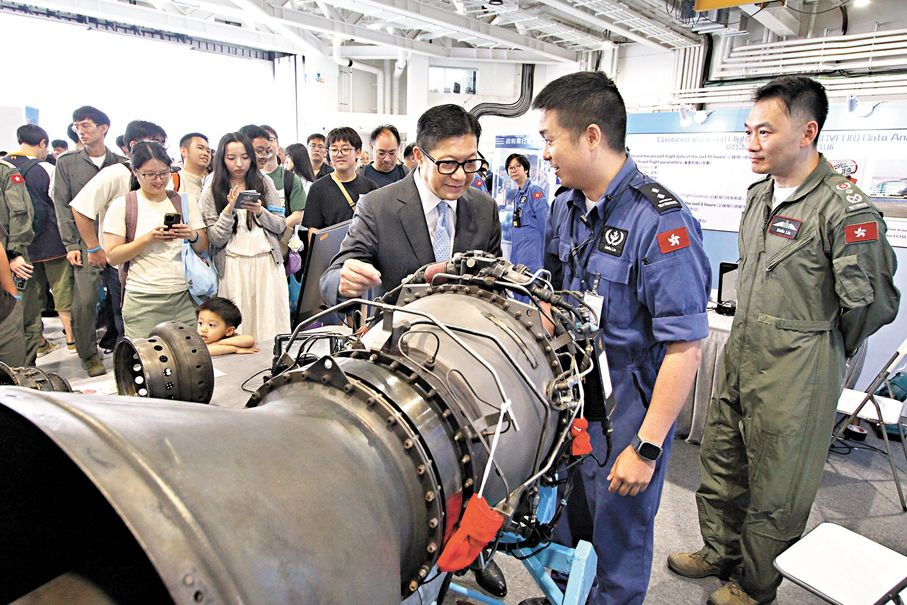 ●保安局局長鄧炳強（右三）聽取特區政府飛行服務隊人員講解飛行器引擎。