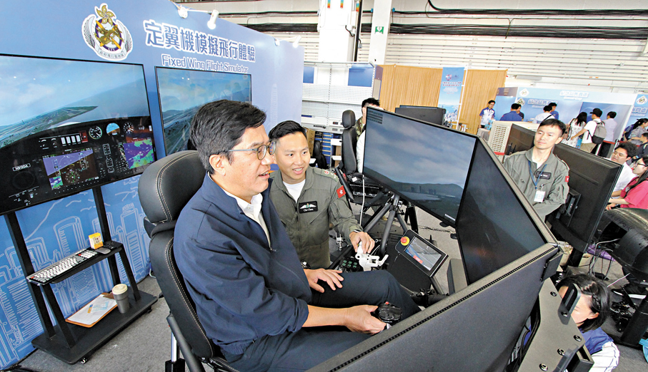 ●財政司副司長黃偉綸（左一）現場體驗定翼機模擬飛行。