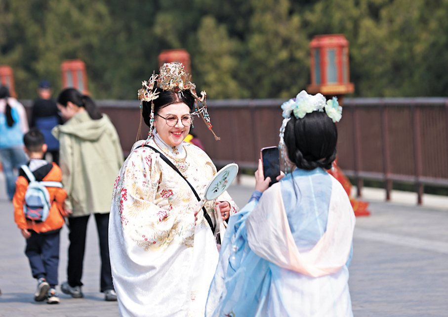 ●內地的入境遊增長勢頭明顯，有學者認為有望成為未來中國消費與服務貿易的重要增長極。圖為北京天壇公園外國遊客體驗中國傳統服裝。 中新社