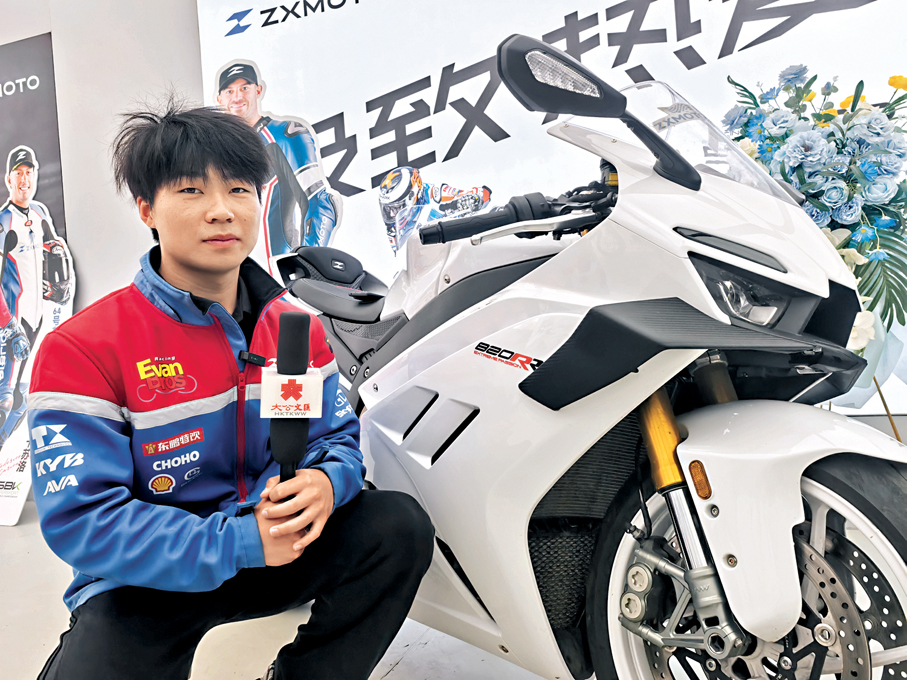 ●武漢光谷「張雪機車」門店銷售人員介紹奪冠的仿賽車型820RR。 香港文匯報記者張帥  攝