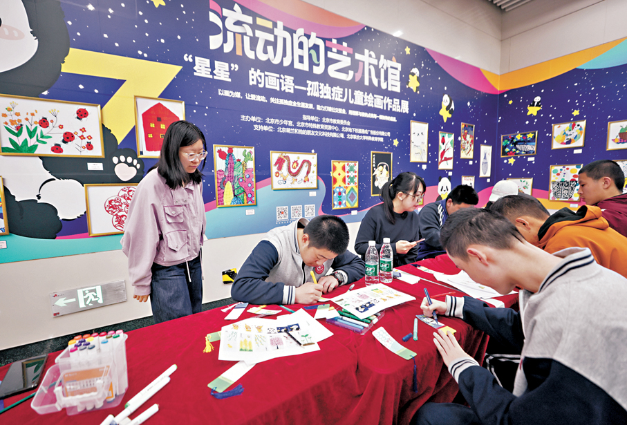 ●4月2日，北京地鐵6號線朝陽門站內舉辦「流動的藝術館——以畫為媒，用愛點亮『星』空」融合公益活動。圖為孤獨症兒童繪製書籤。 中新社
