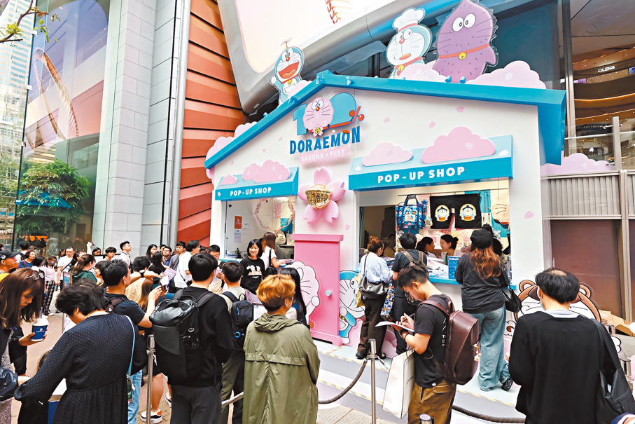 ●多啦A夢展人潮湧動，限定店大排長龍。場內布置了櫻花主題展品，粉絲爭相打卡。 香港文匯報記者涂穴  攝