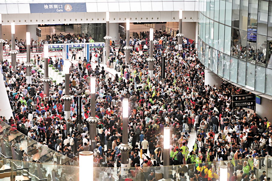 ●香港文匯報記者昨日到西九龍高鐵站直擊，現場呈現一派熙熙攘攘的熱鬧景象，處處可見人潮聚集，檢票閘口擠滿等候的乘客。 香港文匯報記者北山彥  攝